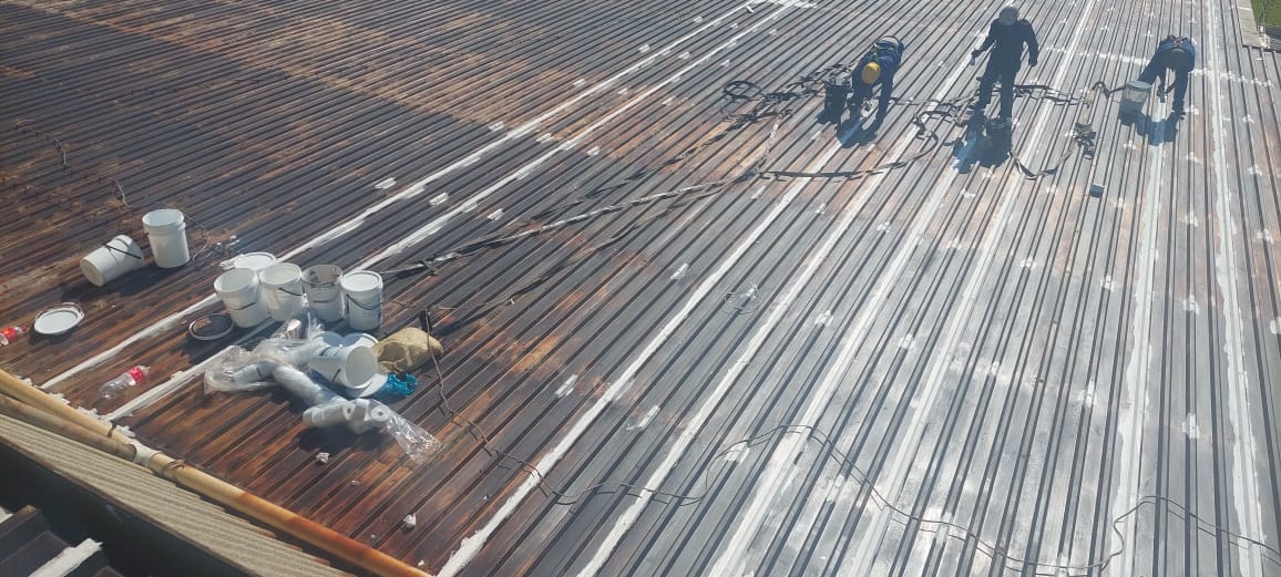 Rusted roof sheets being prepared for coating
