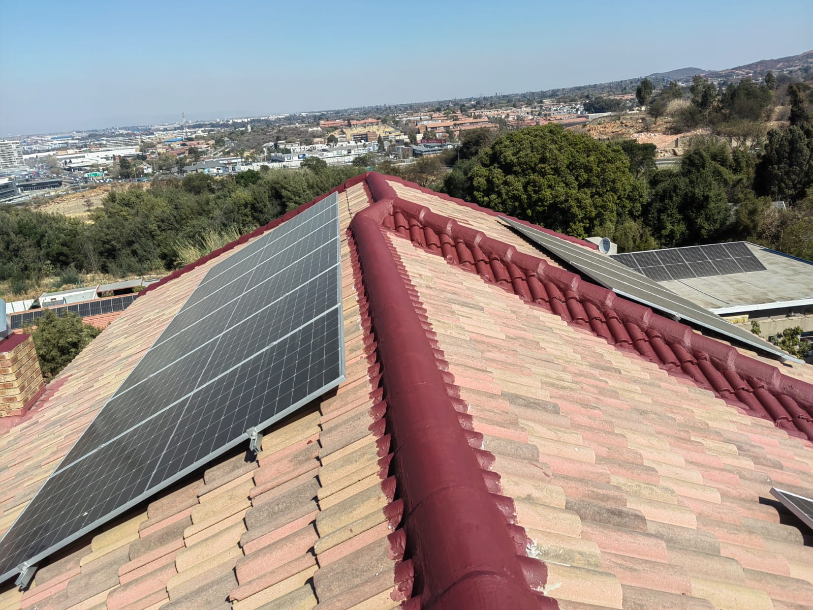 Tiled roof with resealed ridge tiles and solar panels